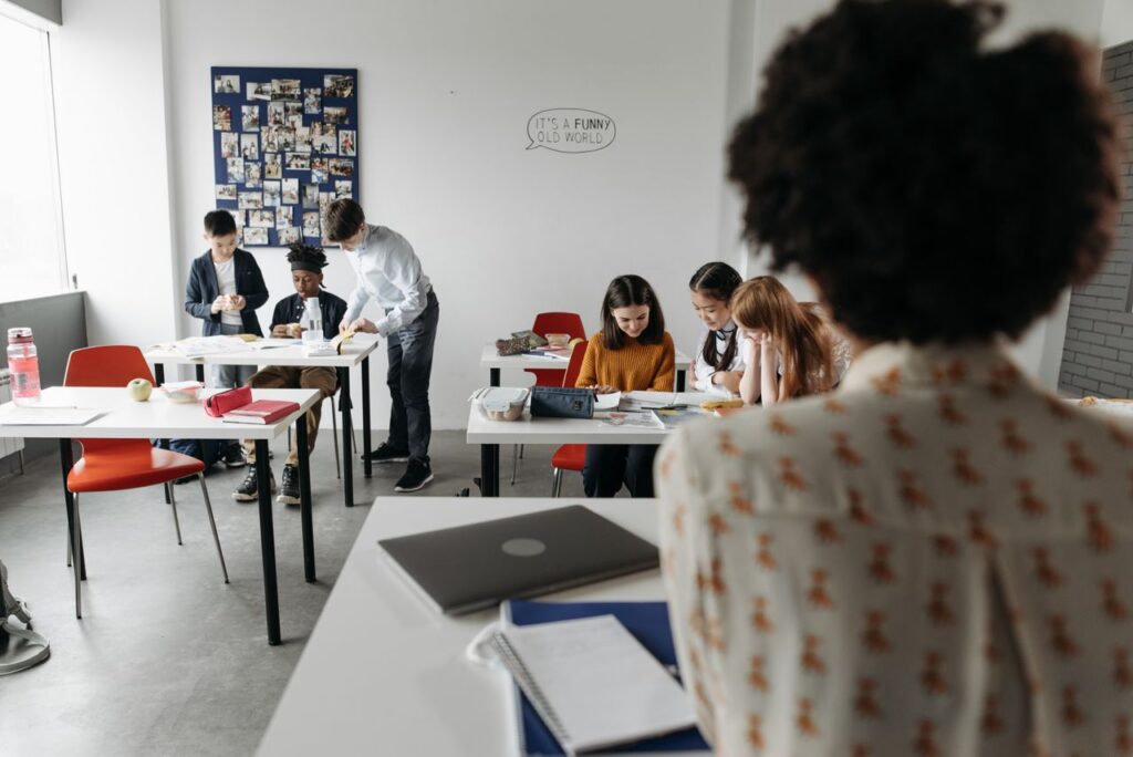 Students focused in a modern classroom with diverse activities and interactions.