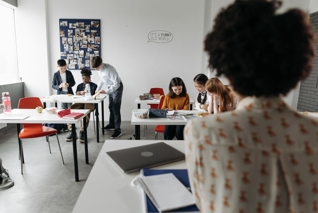 Students focused in a modern classroom with diverse activities and interactions.